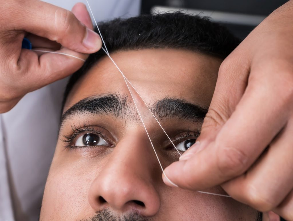 Facial hair removal eyebrows threading procedure in beauty salon