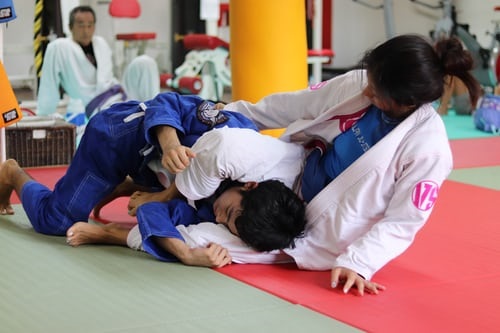 Judo instructor demonstrating a leg locking move on a partner
