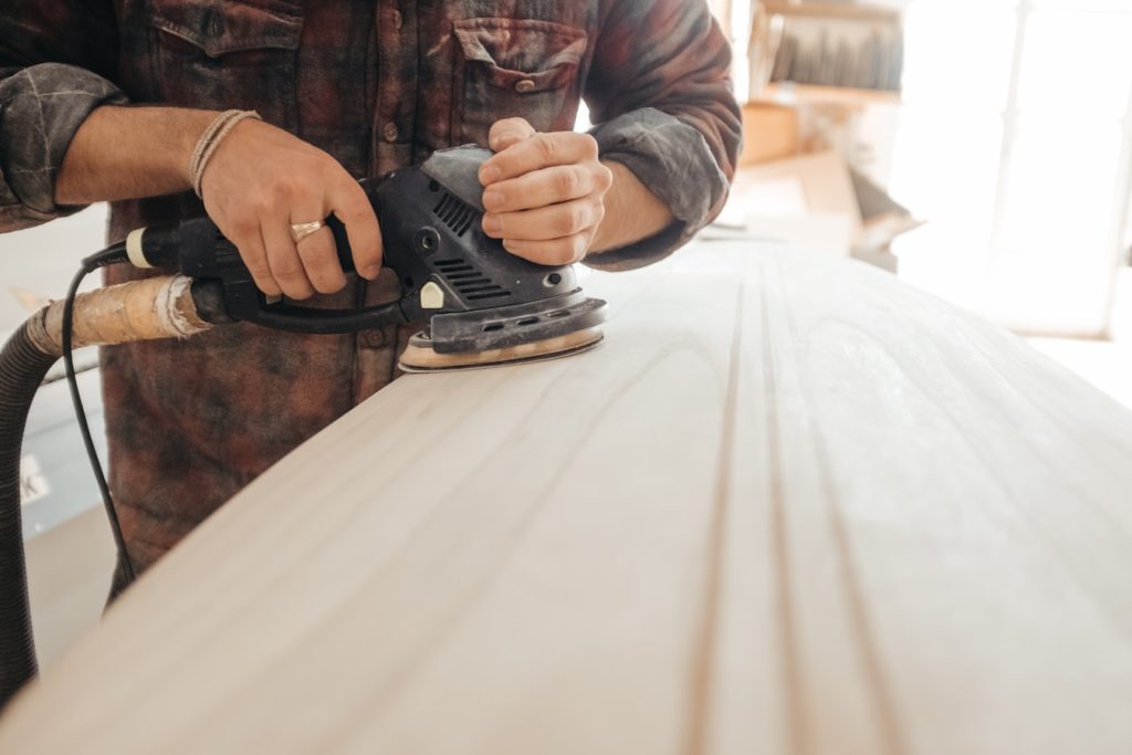 Carpenter sanding a piece of wood