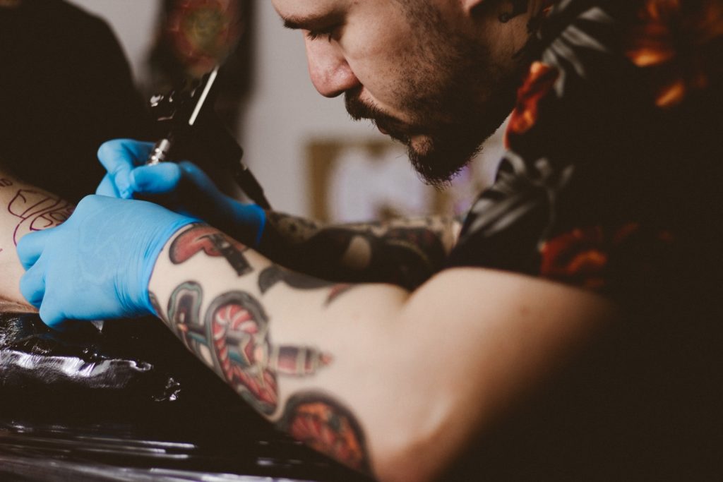 Close up of a tattoo artist tattooing a client's arm