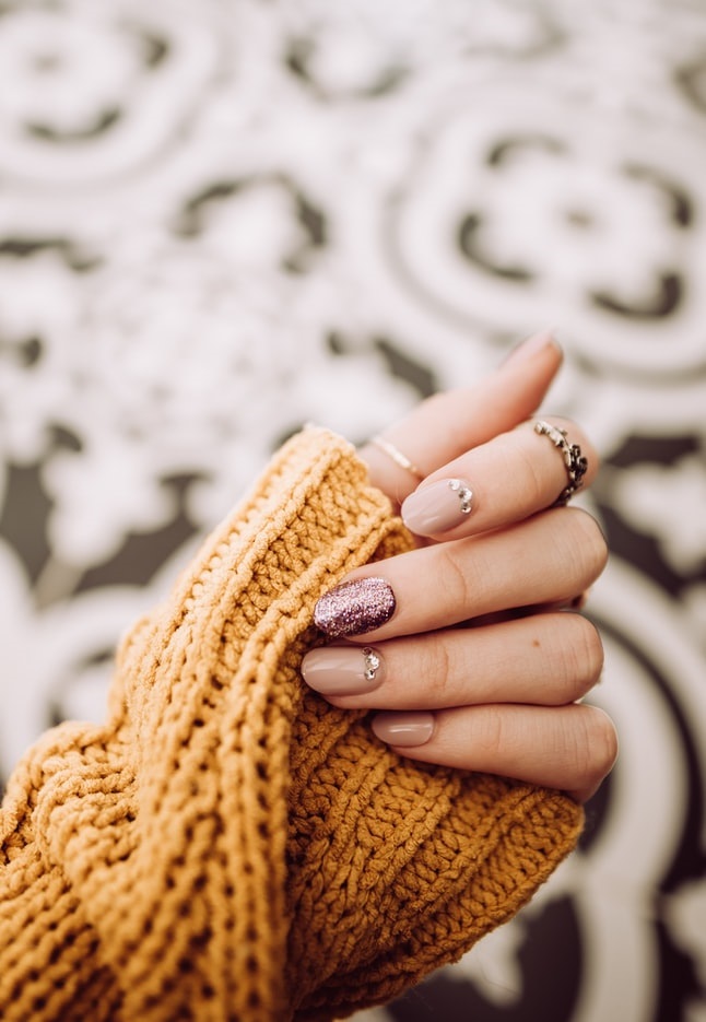 Uniquely painted fingernails over sweater sleeve