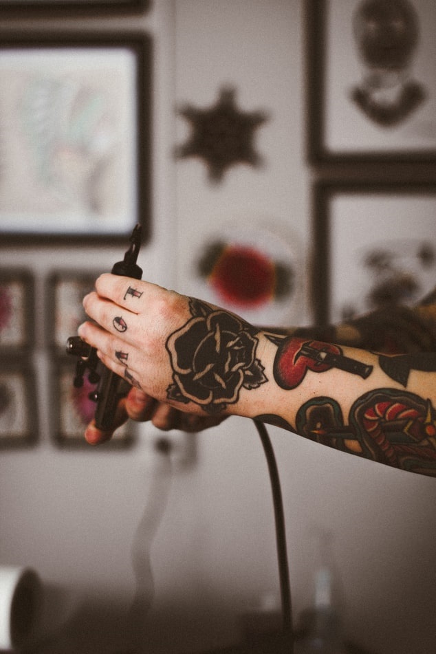 Tattoo artist holding tattoo equipment