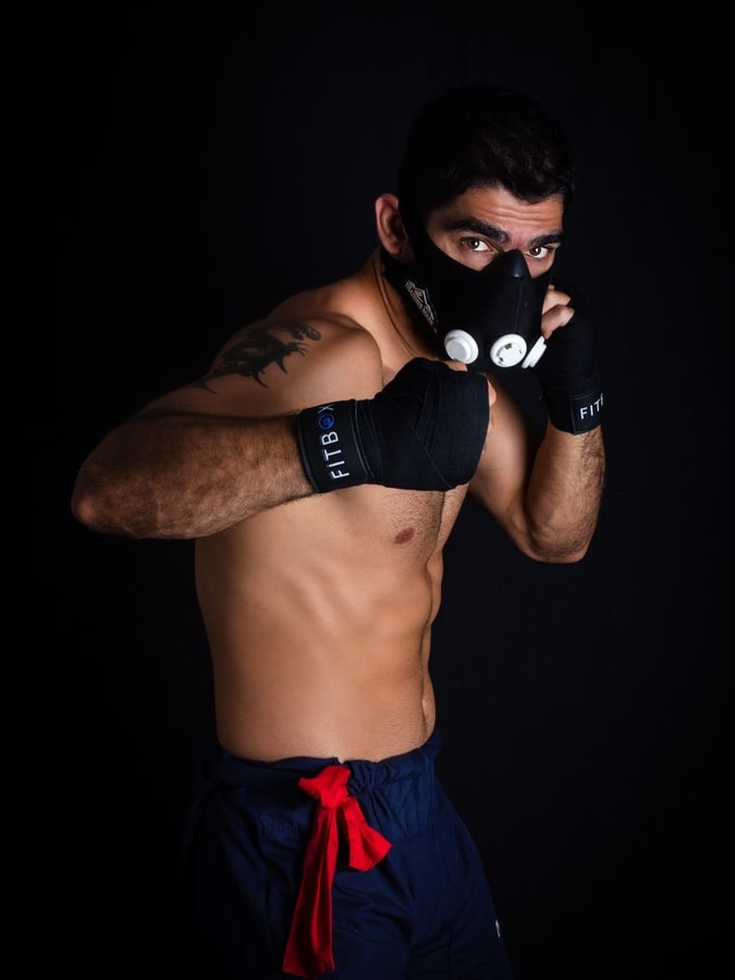 MMA instructor with mask on throwing an elbow
