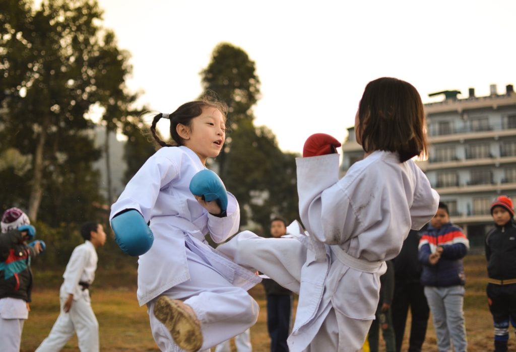 Children practicing kickboxing in a park