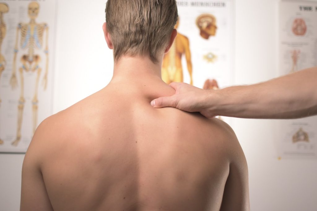 Physical therapist massaging client's shoulder muscles