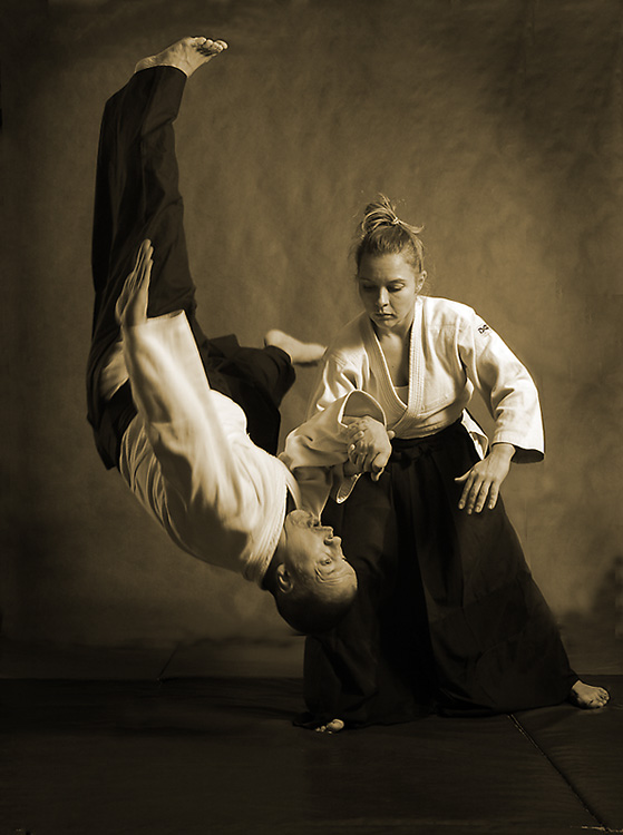 Aikido instructor working with partner to demonstrate a takedown move