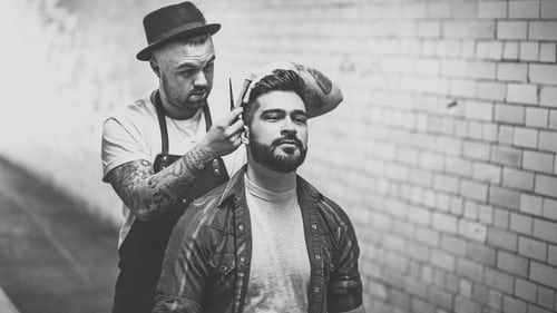 Barber trimming client's hair