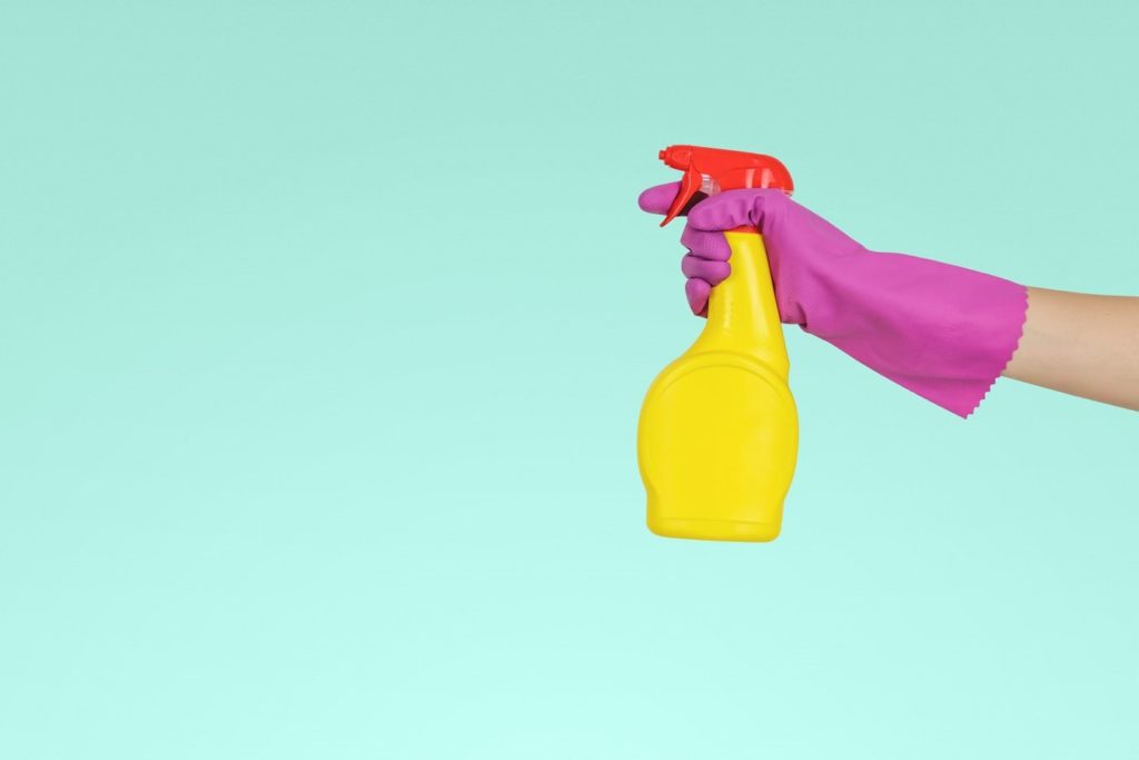 Home cleaner holding a spray bottle of cleaning solution