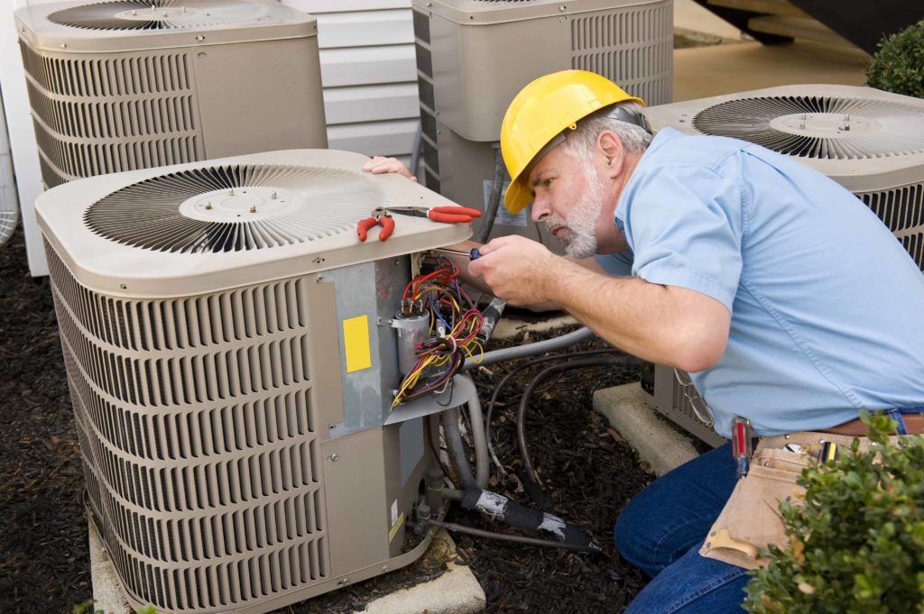 HVAC contractor repairing an air conditioner unit