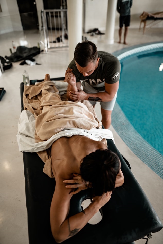 Massage therapist using elbow to massage client's upper leg