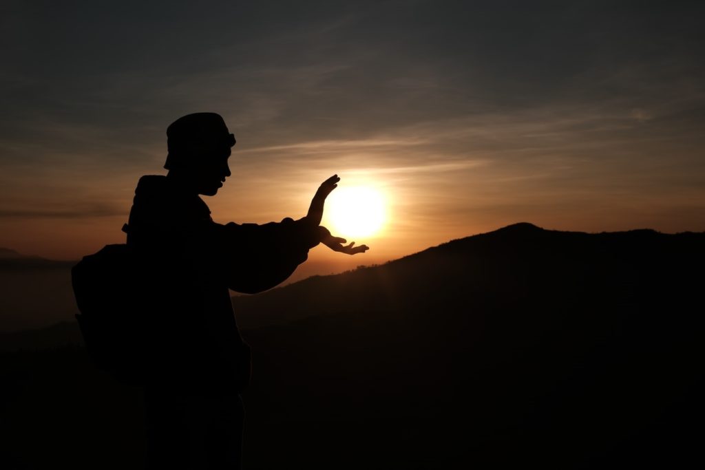 Person doing a Kung Fu pose with hands around the shape of the Sun