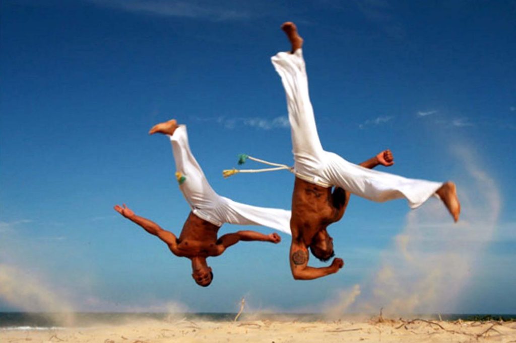 Capoeira instructors performing flipping synchronized moves