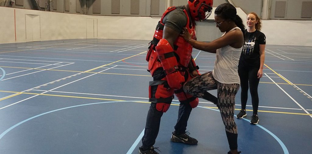 Self defense instructor coaching a female student through moves