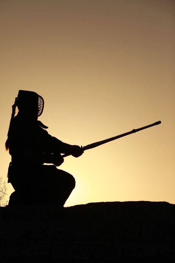 Silhouette of a Kendo instructor posing with a Shinai