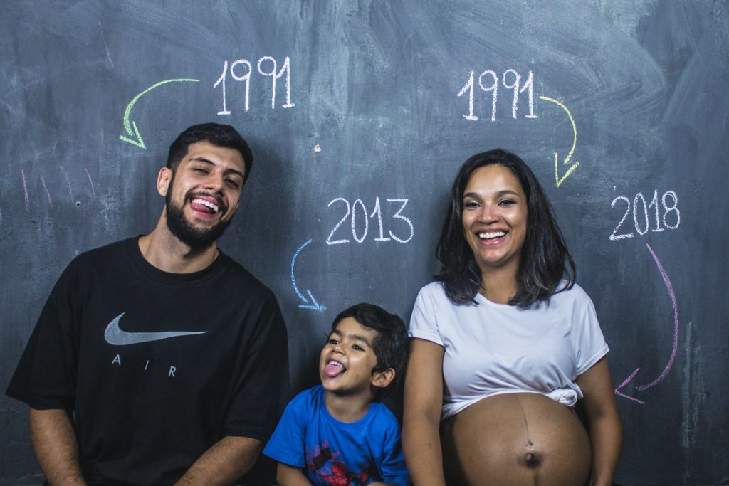 Family posing in front of a chalkboard which points out which year they were born
