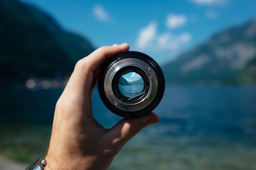 Picture of a camera lens showing a clearer image of a lake and mountains