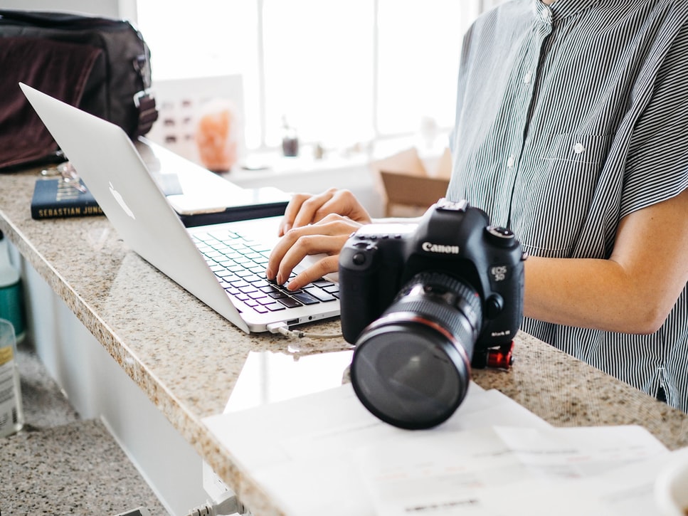Real estate photographer uploading photos from camera to laptop