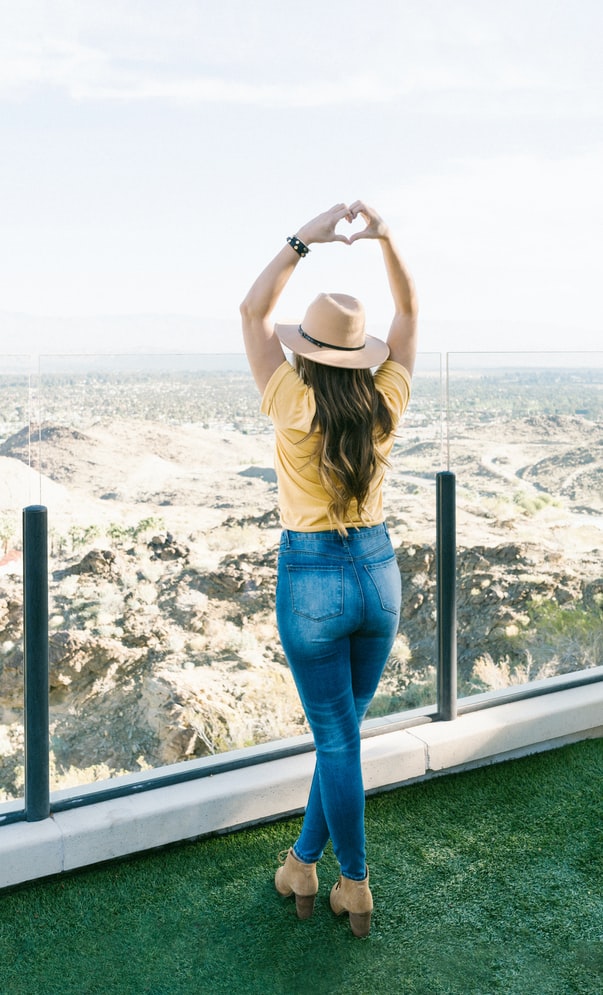 Life coach holding up the heart symbol with her hands while overlooking the desert