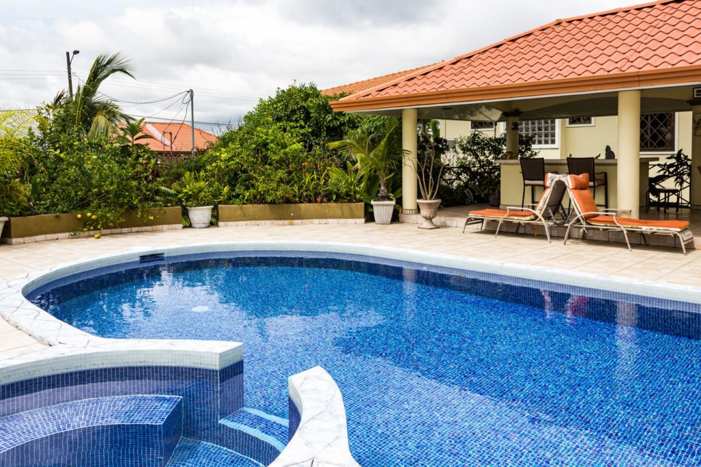 Staged photo of a backyard area with a pool and hot tub