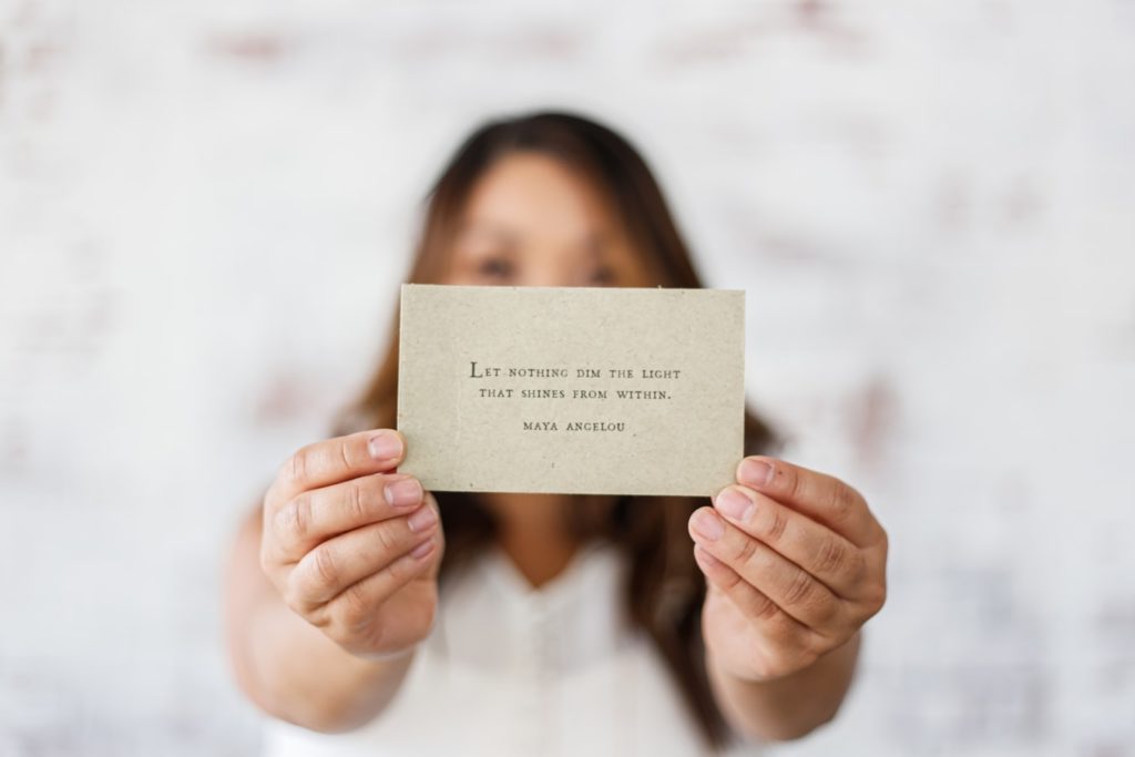 Life coach holding a card that reads "Let nothing dim this light that shines from within."