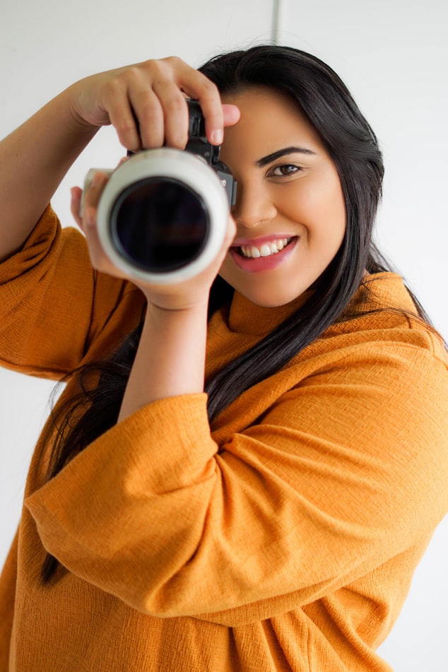 Fashion photographer posing while taking a photo