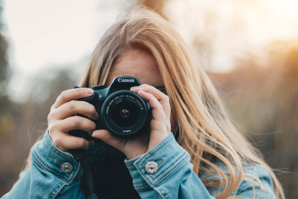 Freelance photographer focusing the lens on her camera