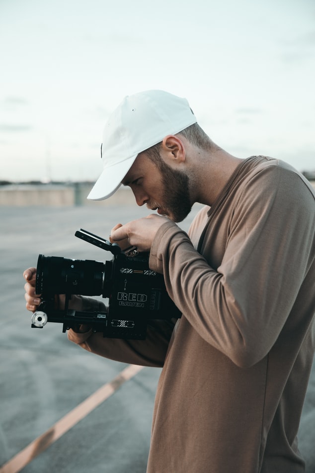 Freelance videographer framing a shot with a handheld camera