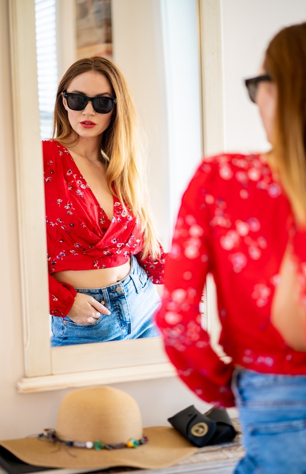 Model posing in a mirror with sunglasses on